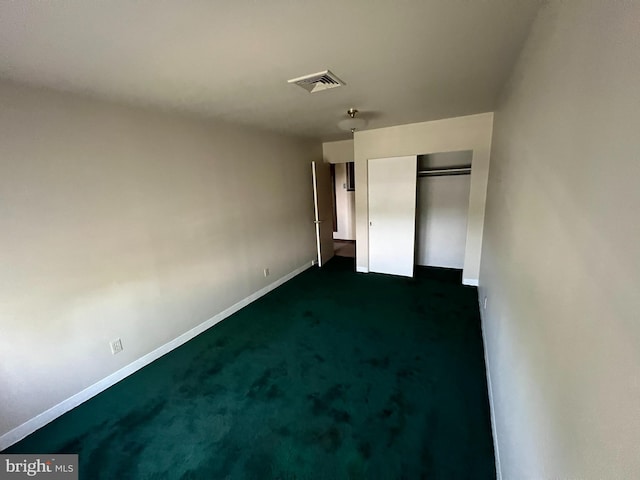 unfurnished bedroom featuring a closet and dark carpet