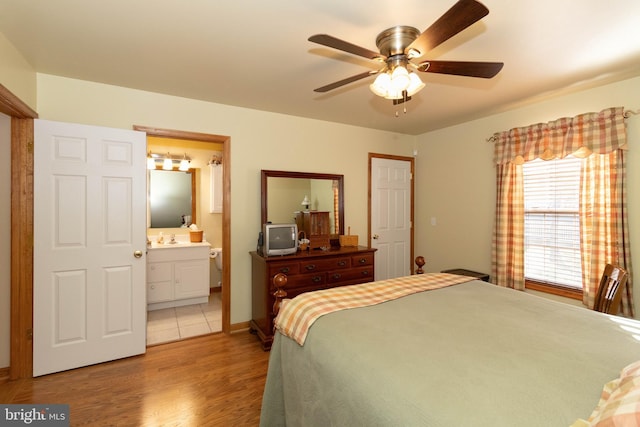 bedroom with ensuite bath, ceiling fan, light hardwood / wood-style flooring, and sink