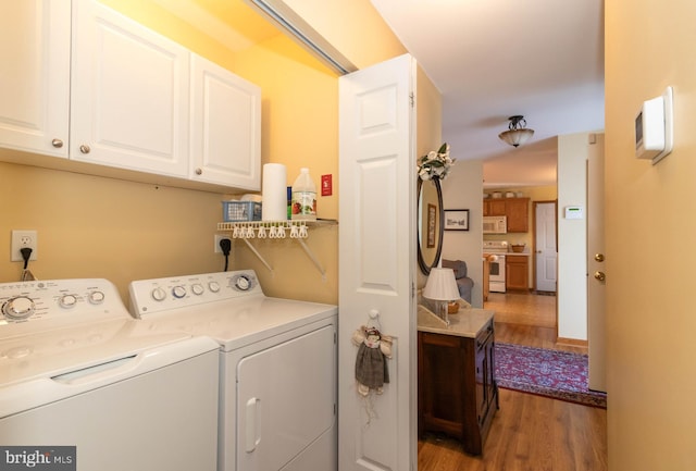 laundry area with separate washer and dryer and dark hardwood / wood-style flooring