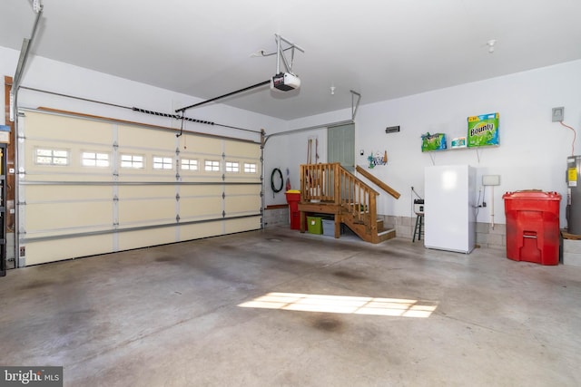 garage with white refrigerator, electric water heater, and a garage door opener