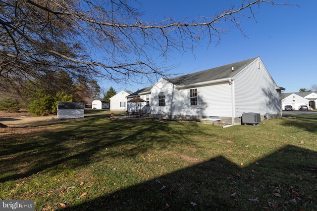 view of side of home featuring central AC and a yard