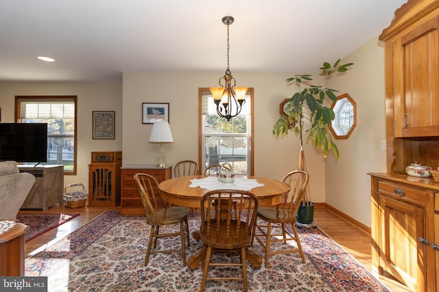 dining room with a chandelier, light hardwood / wood-style floors, and a wealth of natural light