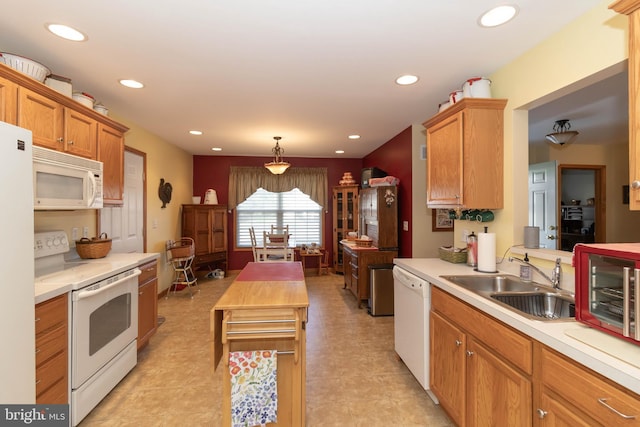 kitchen with decorative light fixtures, light tile patterned flooring, white appliances, and sink