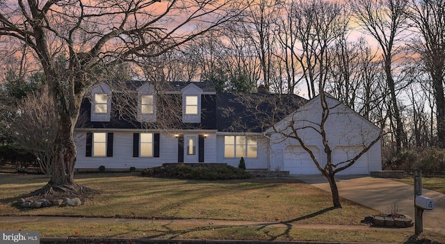 new england style home with a garage and a yard