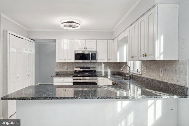 kitchen featuring white cabinets, sink, dark stone countertops, kitchen peninsula, and stainless steel appliances