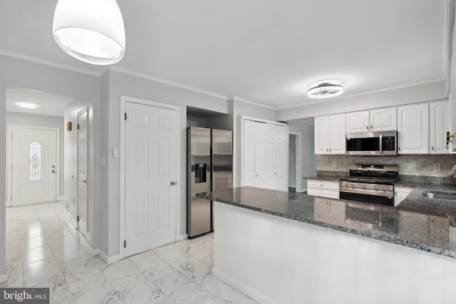 kitchen featuring dark stone counters, white cabinets, sink, decorative backsplash, and stainless steel appliances