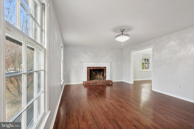 unfurnished living room featuring a fireplace and dark wood-type flooring