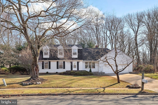 new england style home featuring a garage and a front lawn