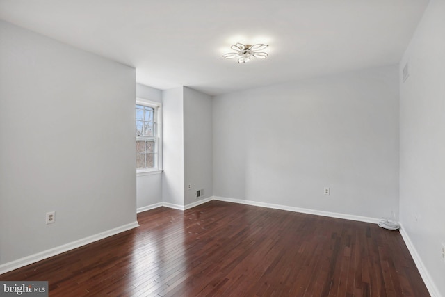 unfurnished room with dark hardwood / wood-style flooring