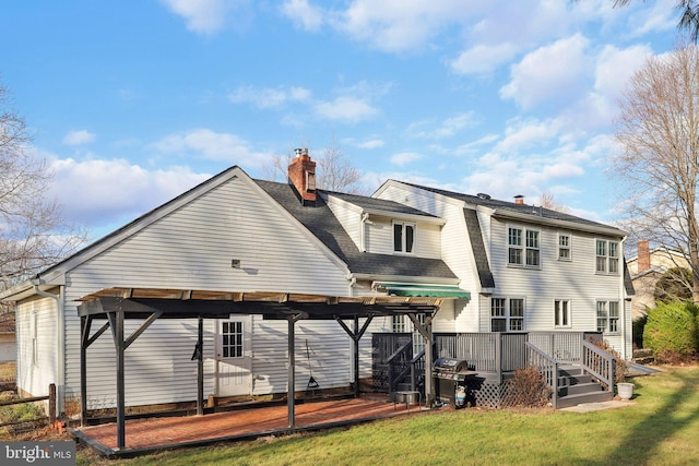 rear view of property with a lawn and a wooden deck