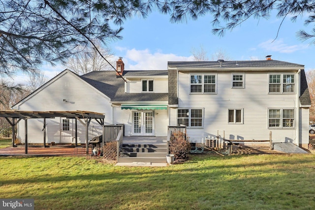 rear view of property featuring a pergola, a deck, and a lawn