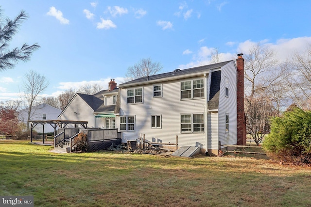 rear view of property with a deck and a yard