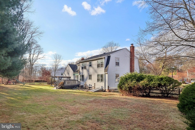 back of house with a lawn and a wooden deck