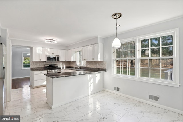 kitchen featuring hanging light fixtures, white cabinetry, kitchen peninsula, and appliances with stainless steel finishes