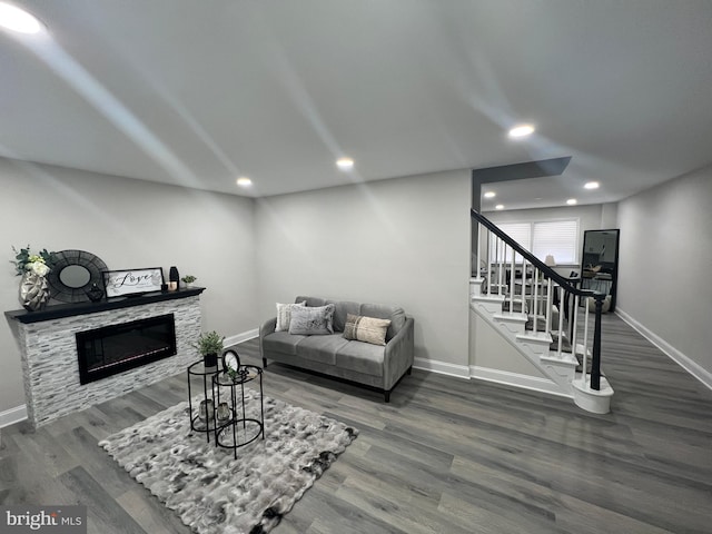 living room featuring dark hardwood / wood-style flooring and a stone fireplace