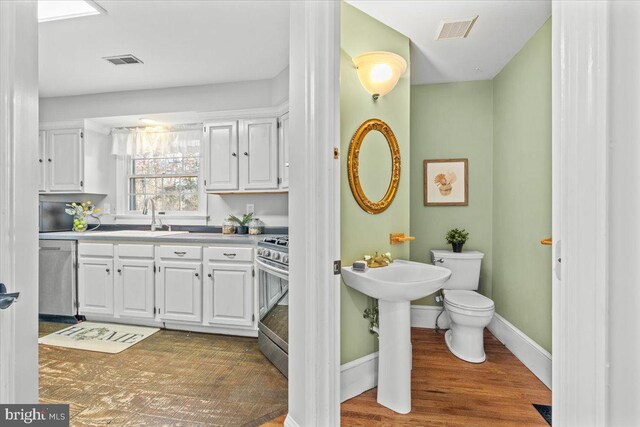 bathroom featuring sink, wood-type flooring, and toilet