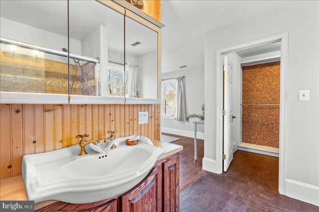 bathroom with wooden walls, vanity, and hardwood / wood-style flooring