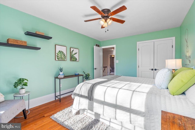 bedroom featuring ceiling fan, wood-type flooring, and a closet