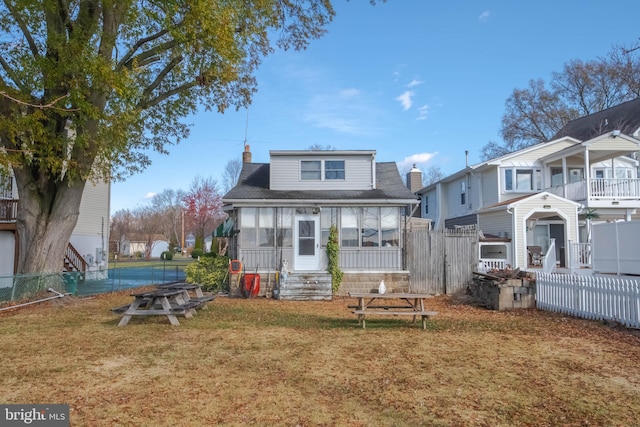 back of property featuring a lawn and a sunroom