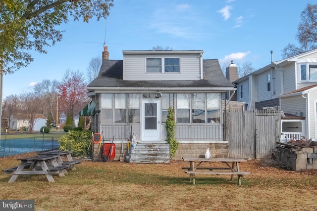 view of front facade with a sunroom and a front yard