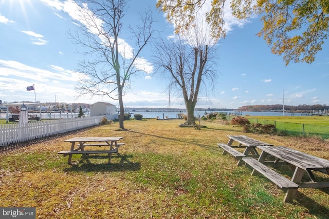 view of property's community with a lawn and a water view