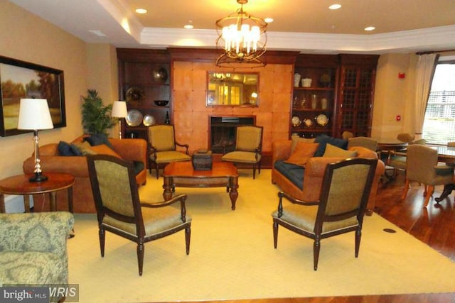 interior space with a chandelier, ornamental molding, hardwood / wood-style flooring, and a tray ceiling