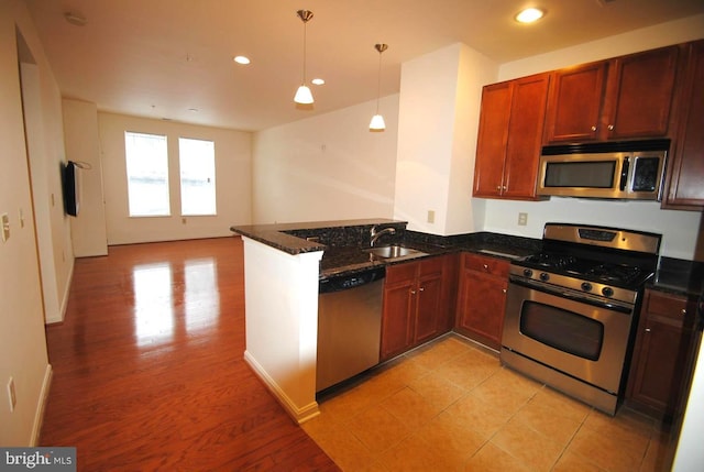 kitchen featuring kitchen peninsula, sink, appliances with stainless steel finishes, and light hardwood / wood-style flooring