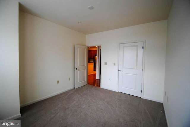 unfurnished bedroom with dark carpet