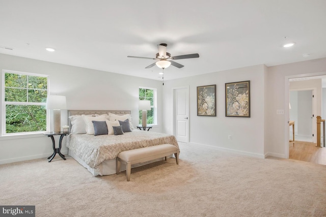 carpeted bedroom featuring ceiling fan and multiple windows