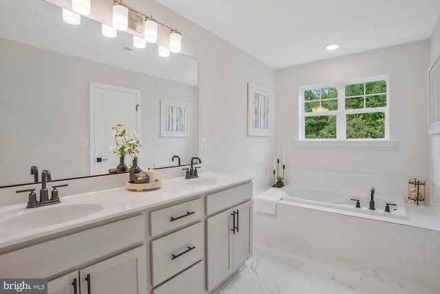 bathroom featuring vanity and tiled tub