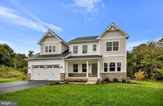 craftsman-style home featuring central AC unit, a garage, and a front lawn