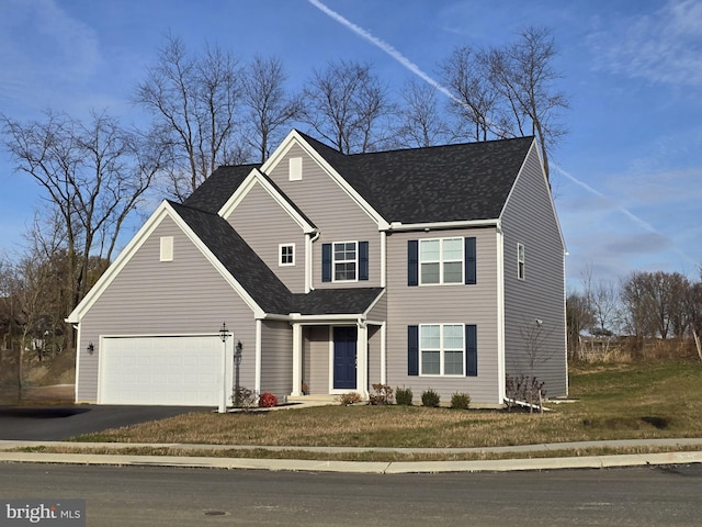 view of front of home with a front yard and a garage