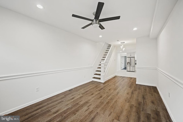 unfurnished living room with ceiling fan and dark wood-type flooring