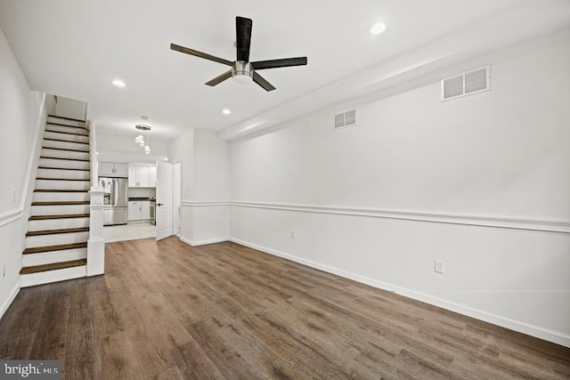 unfurnished living room with dark hardwood / wood-style flooring and ceiling fan