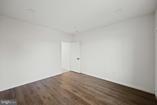 unfurnished room with dark hardwood / wood-style flooring