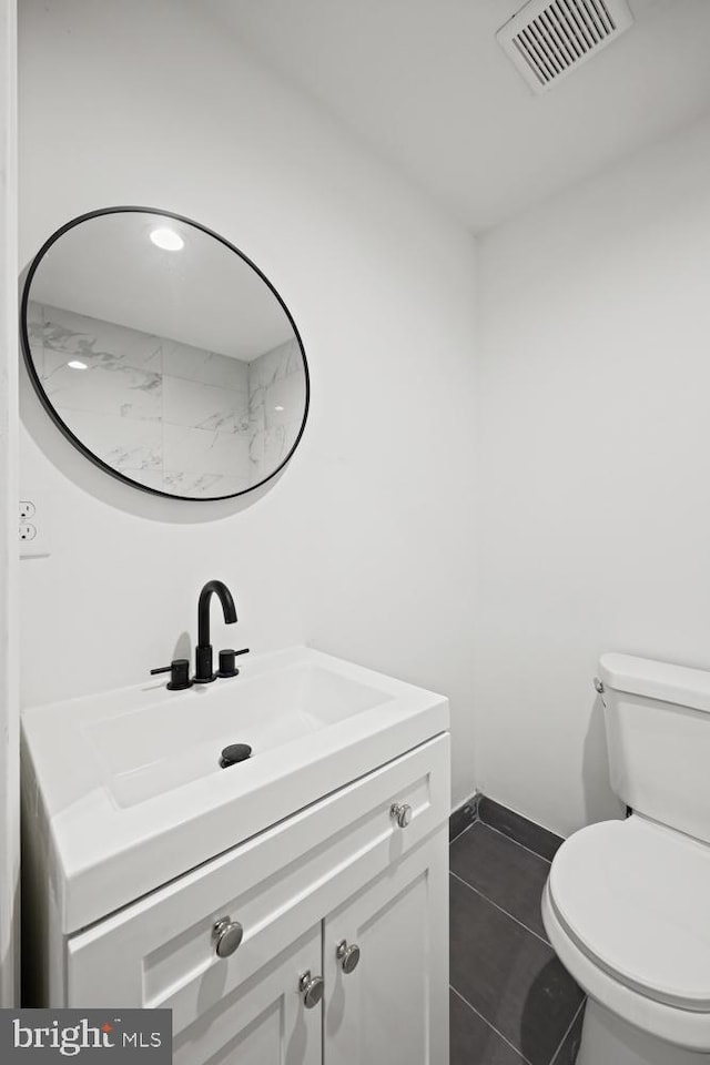 bathroom featuring tile patterned flooring, vanity, and toilet