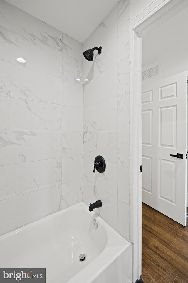 bathroom featuring hardwood / wood-style floors and tiled shower / bath