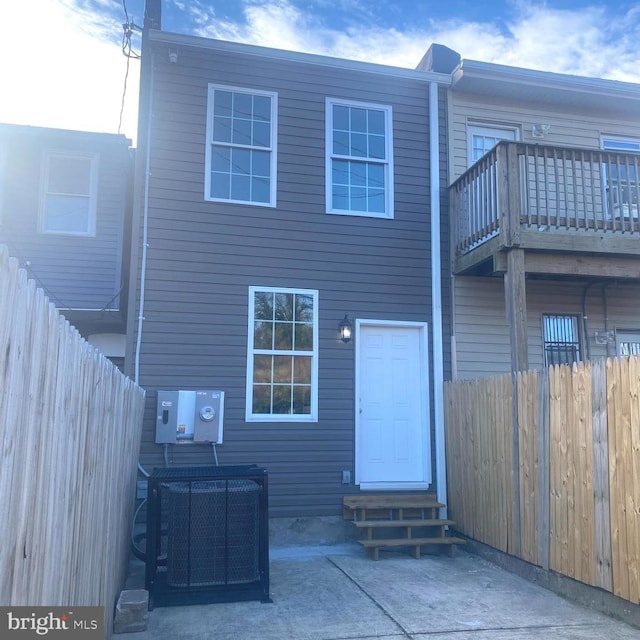 rear view of property featuring a balcony and cooling unit