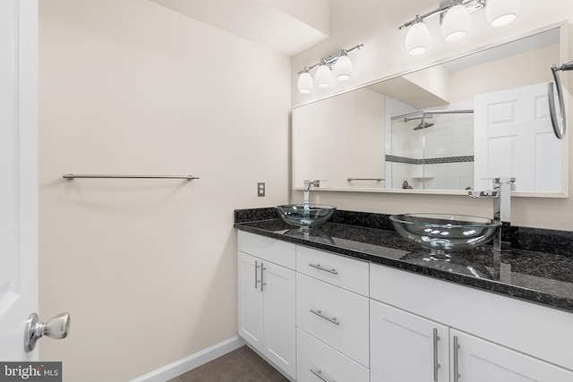 bathroom with tiled shower, vanity, and tile patterned floors