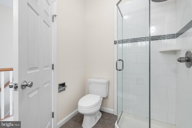 bathroom with tile patterned floors, a shower with shower door, and toilet