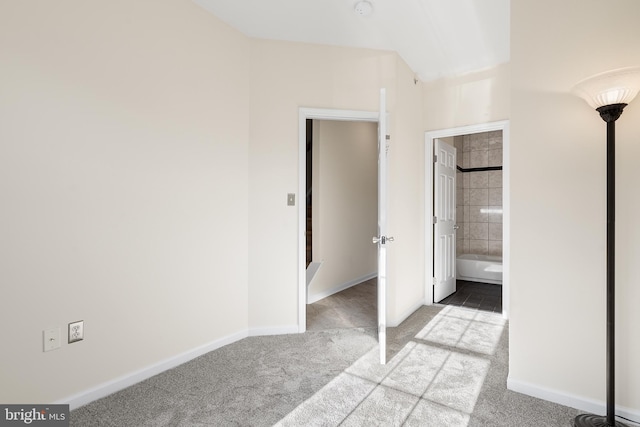 unfurnished bedroom featuring light colored carpet and connected bathroom