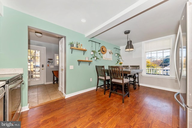 dining area with hardwood / wood-style flooring and beam ceiling