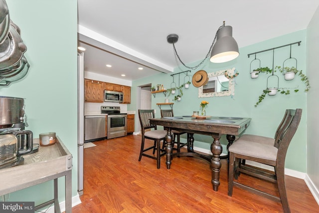 dining area with light hardwood / wood-style floors and beam ceiling