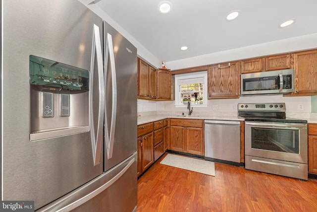 kitchen featuring stainless steel appliances, hardwood / wood-style flooring, and sink