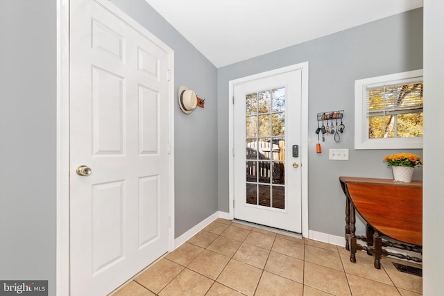 doorway to outside with light tile patterned flooring and a wealth of natural light