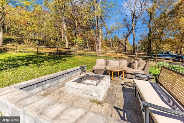 view of patio with an outdoor living space with a fire pit