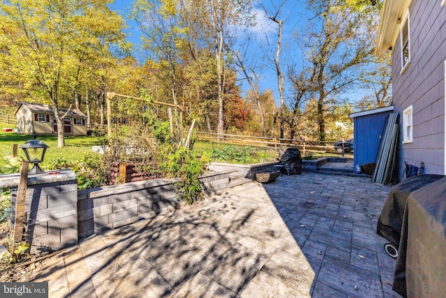 view of patio / terrace featuring a grill and an outdoor structure