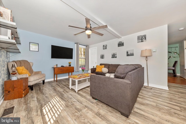 living room featuring beam ceiling, light hardwood / wood-style floors, and ceiling fan