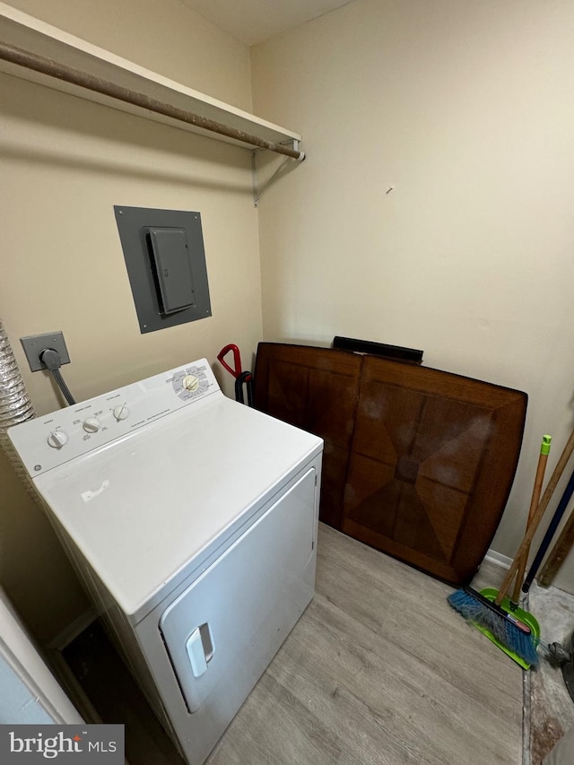 laundry area featuring washer / clothes dryer, light hardwood / wood-style flooring, and electric panel