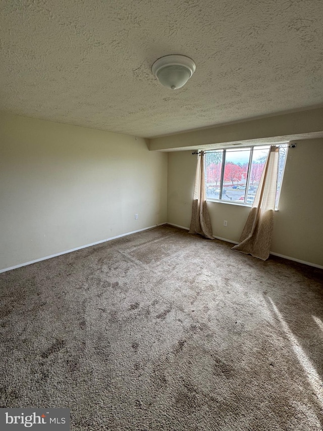 carpeted empty room with a textured ceiling